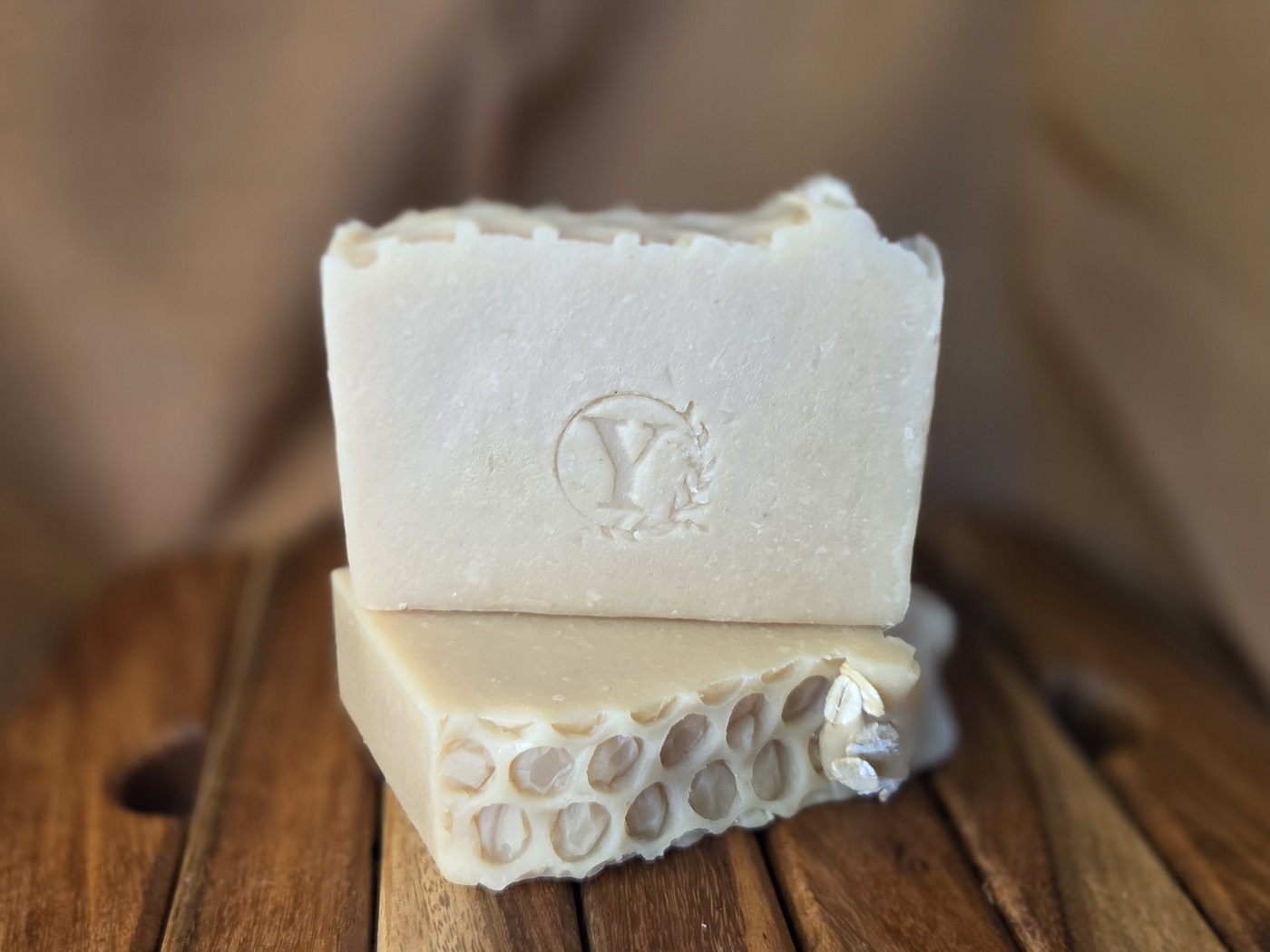Cream soap bar stamped with a Y, stacked on a honeycomb-textured bar
