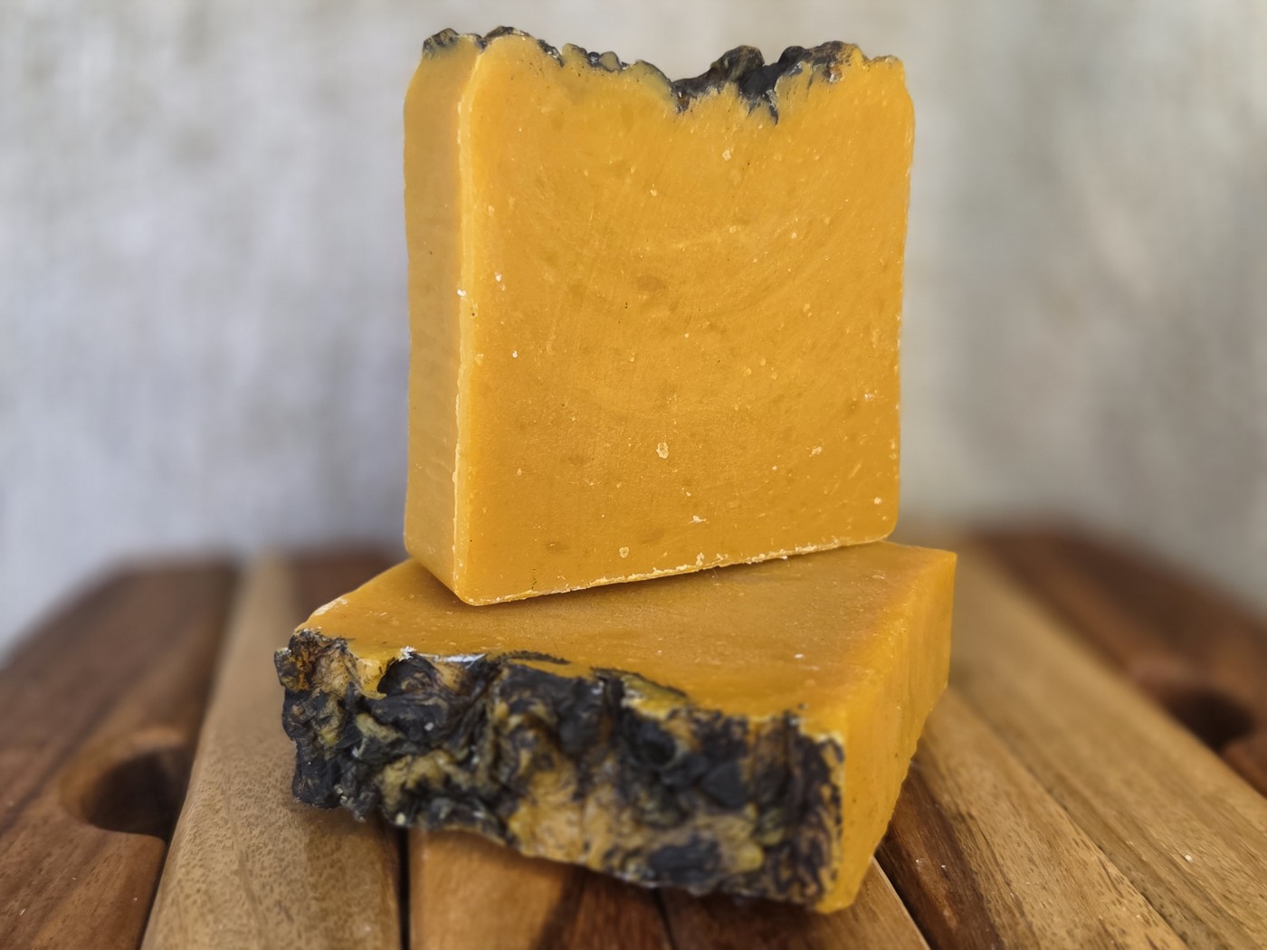 Two saffron-orange soap bars with dark crusted tops, stacked