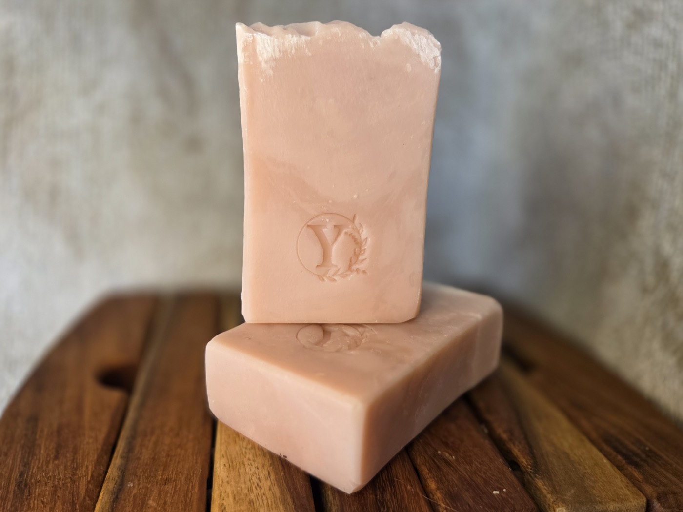 Two dusty pink-mauve marbled soap bars stamped with a Y