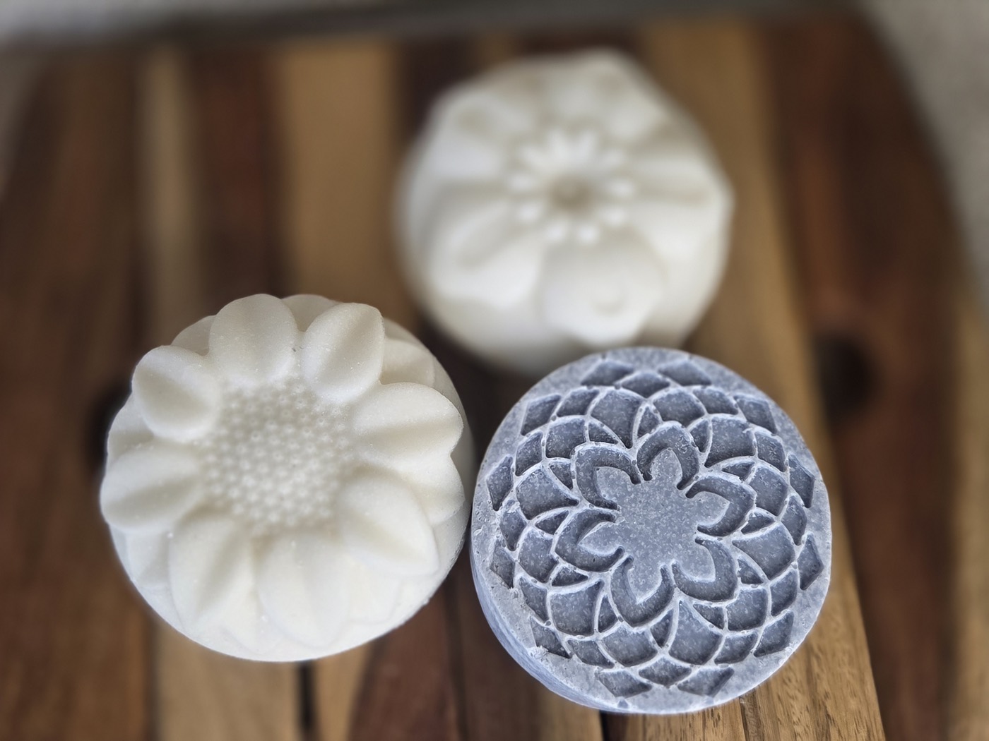 Blue-grey mandala-patterned salt soap round beside white flower rounds